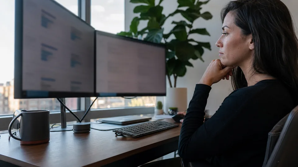 HR director weighing two compliance training vendors on two monitors